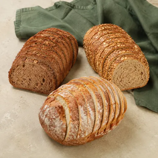 Drei geschnittene Brote: Vollkorn, Mehrkorn mit Saaten und helles Weizenmischbrot.